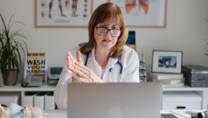 Healthcare professional reviewing data on a laptop