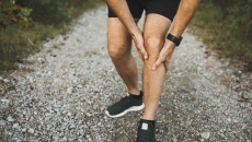 Person holding onto their leg while in the wilderness