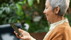 A smiling elderly person using a smartphone