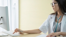 Healthcare provider sitting at a desk while looking at a computer