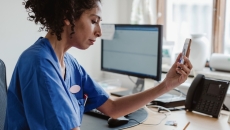 Healthcare professionals interacting with a person on a cell phone