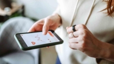 Person with a smart ring looking at an app on their mobile phone