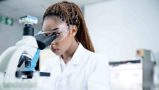 Scientist in a lab looking through a microscope