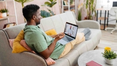 Person sitting on a couch while having a telehealth appointment