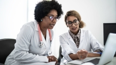 Two healthcare providers on a computer
