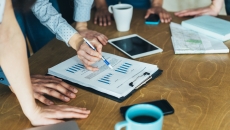 People standing around a table looking at a piece of paper
