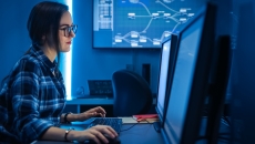 Person sitting at a computer while in a dark room