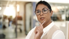 Person sitting in a clinical setting while holding a pen to their chin