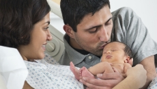 A newborn child with their parents