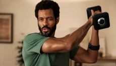 A man lifting a weight wearing the heart rate monitor