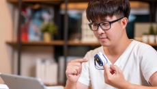 Person in front of laptop with remote medical device on finger