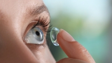 Person inserting a contact lens into their eye
