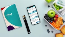 A photo of the Vivoo test kit next to a smartphone and a lunchbox.