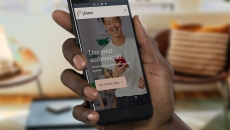 A closeup of a hand holding a smartphone displaying the Plume app.