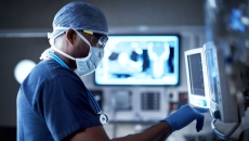 A surgeon looking at a monitor.