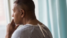 Person standing by a window looking out
