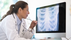 Healthcare professional looking at a computer screen with an x-ray on it