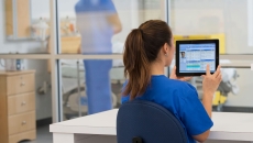 Healthcare provider sitting at a desk in the clinical setting while looking at a computer