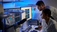 Researchers analysing findings on a desktop computer