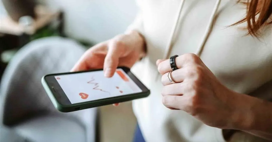 Person with a smart ring looking at an app on their mobile phone