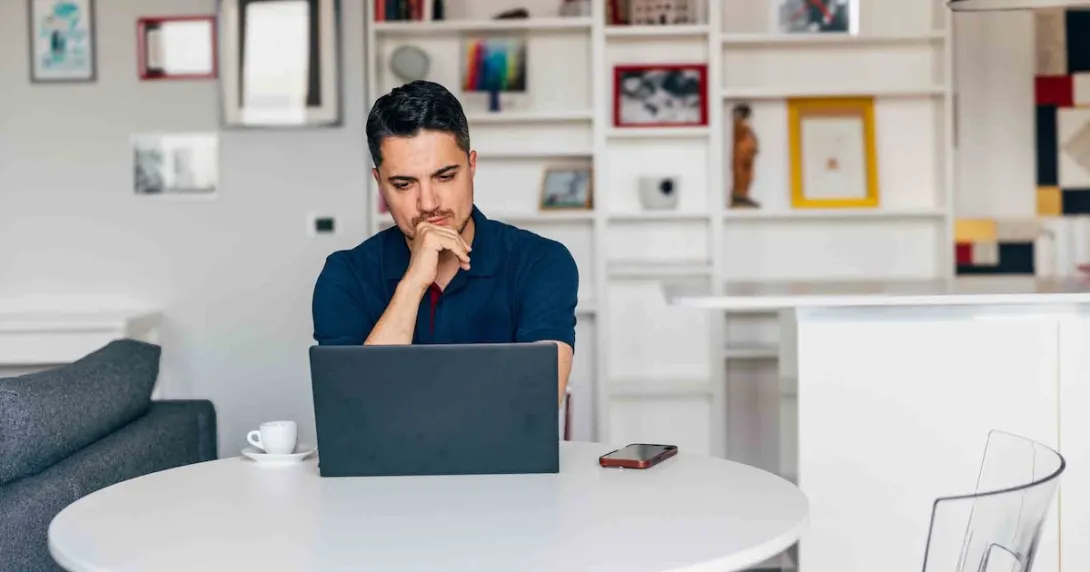 Person on a laptop while sitting at a table