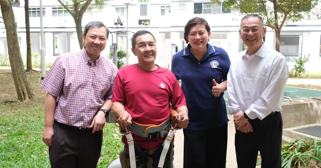 An elderly person wearing an assistive robot developed at NTU Singapore, together with its developers