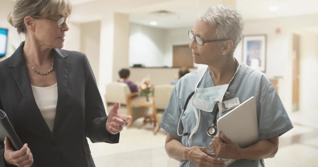 Two people walking through a healthcare facility