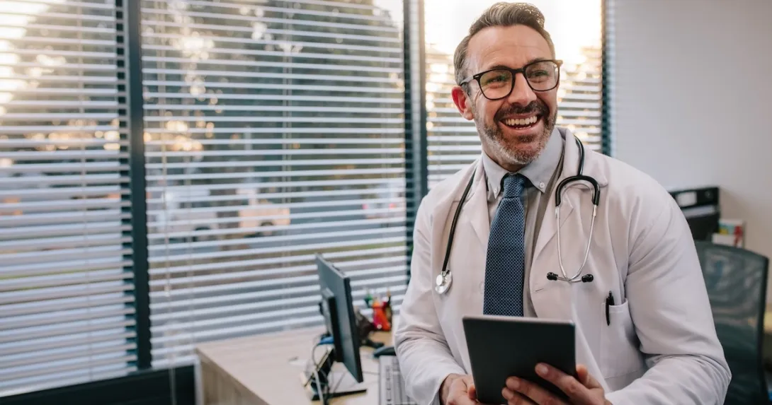 Physician holding a stethoscope and a tablet computer