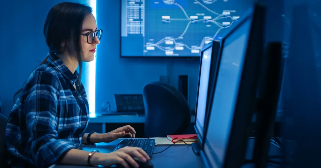 An IT person is working on codes in a desktop computer