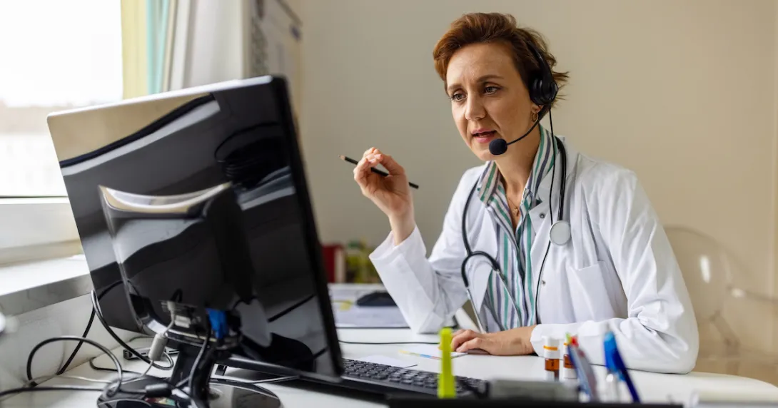 Healthcare provider sitting at a desk while looking at a computer