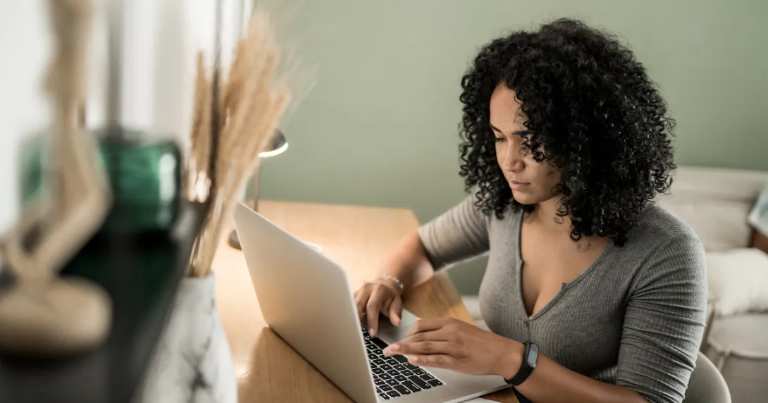 Person sitting at a desk and typing on a computer