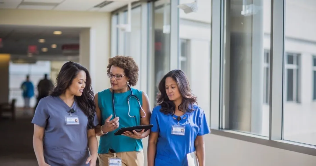 three people walking together in a hospital