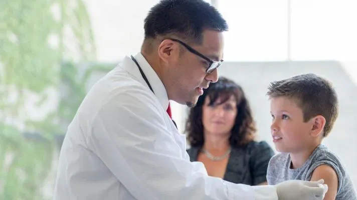 Doctor giving injection to pediatric patient