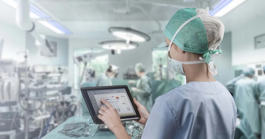 Surgeon in operating room looking at tablet
