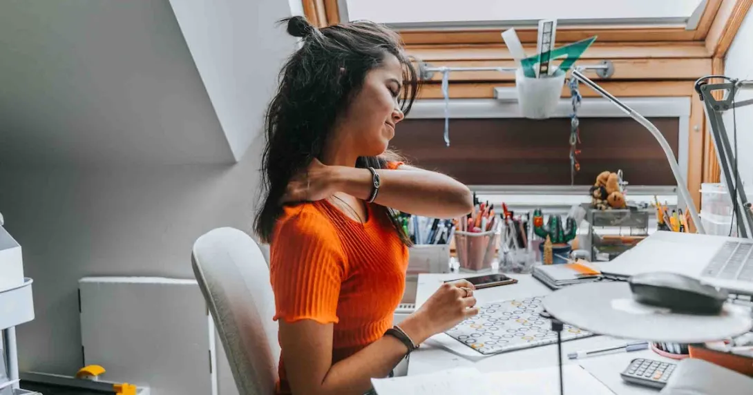 Person grabbing their shoulder due to discomfort