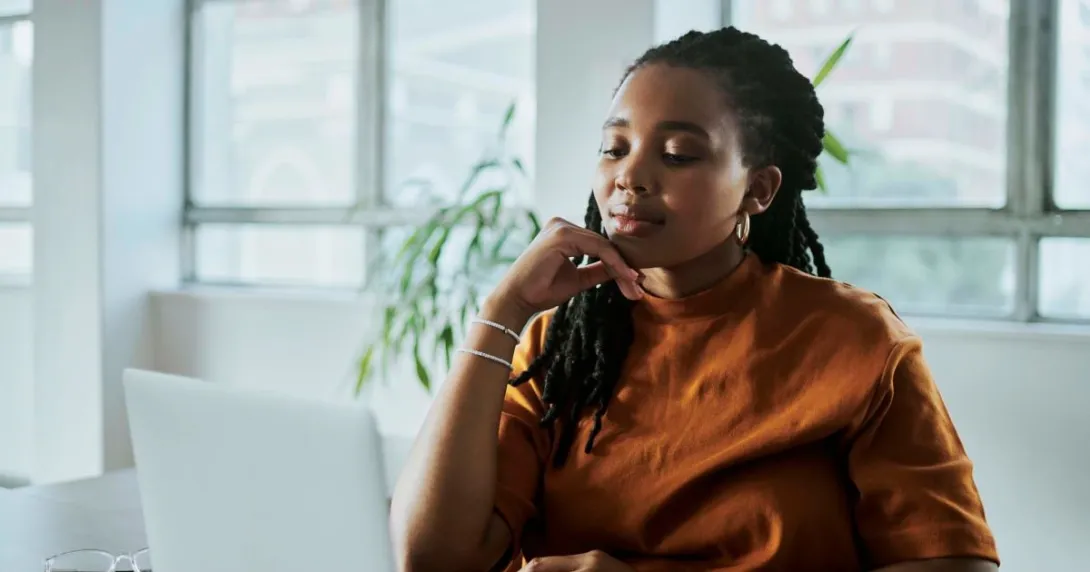 Person in orange shirt looking at computer screen