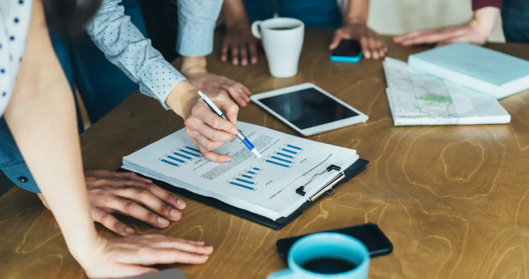 A close-up of workers looking at financial charts