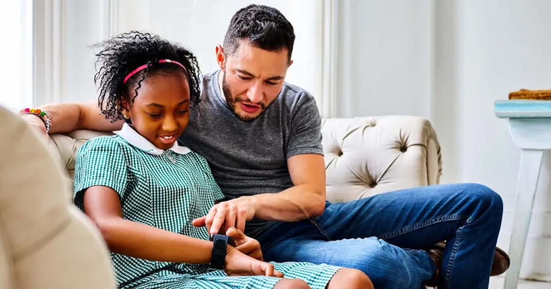 A child setting up a smartwatch with a parent