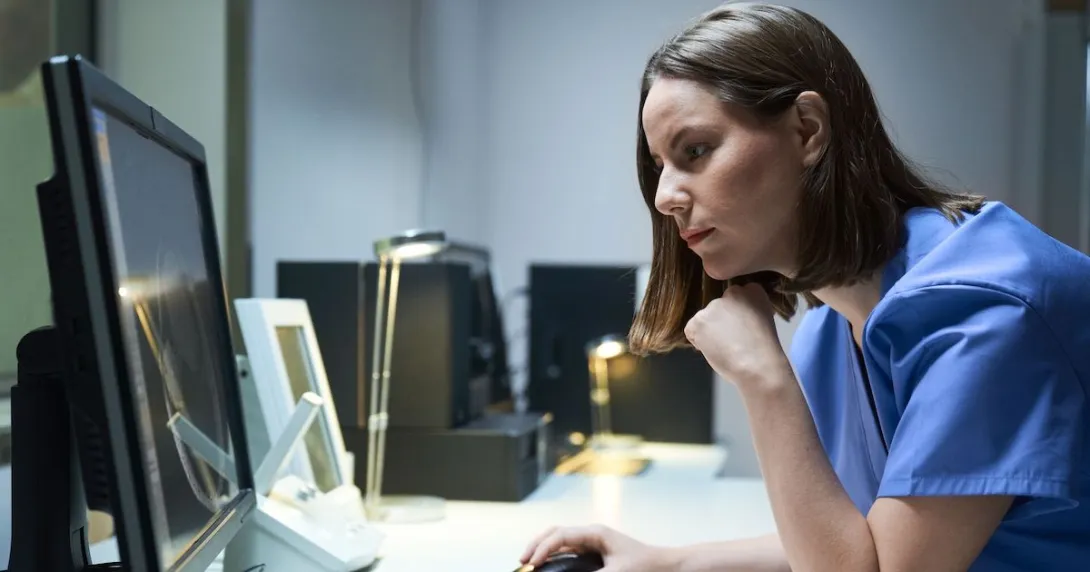 A doctor looking at imaging results on a desktop computer.