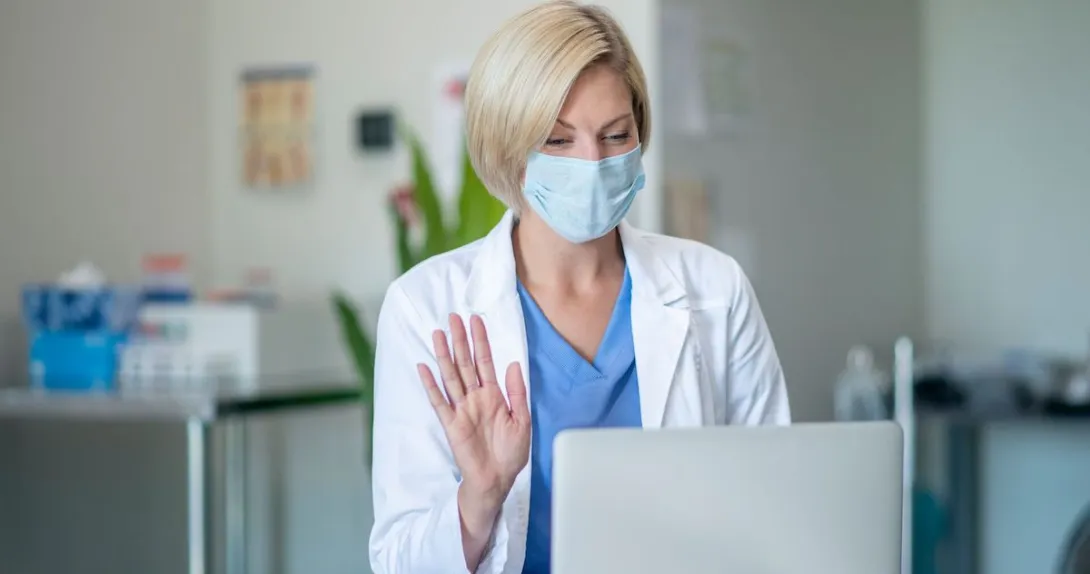 A doctor recording a video on her laptop.