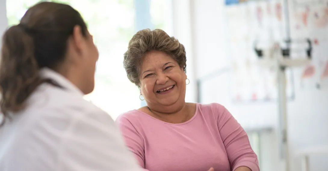 A medical professional talking to a laughing patient