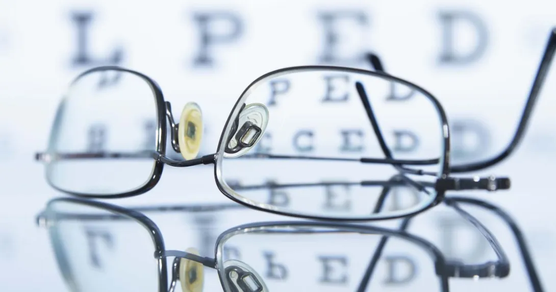 Glasses lying in front of an eye chart