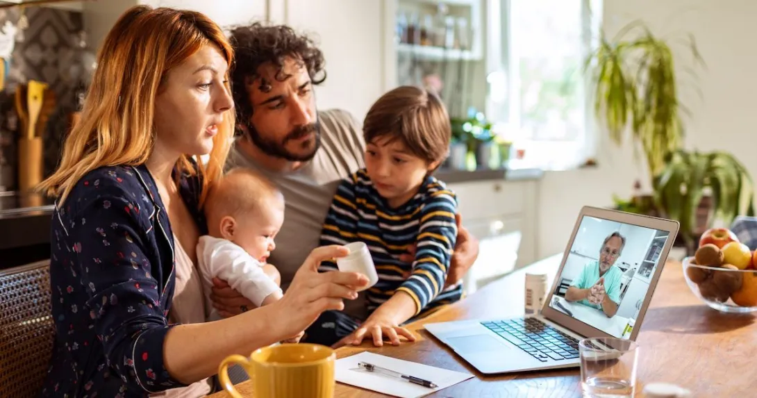 A family talking to a doctor on their laptop.