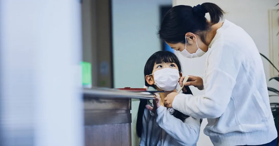 A mom checks a child's temperature before he goes to school