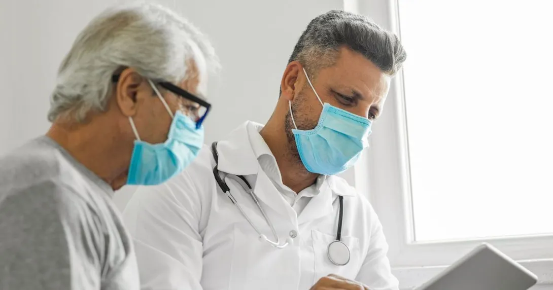 An older man and doctor looking at results on a tablet.