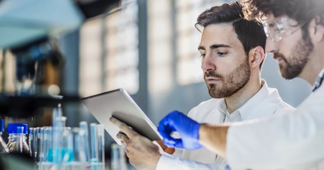 Two scientists looking at a tablet in a lab
