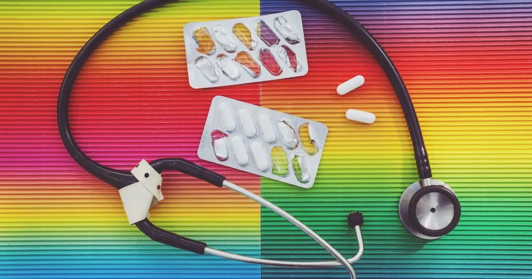 Stethoscope and pills on a colorful background