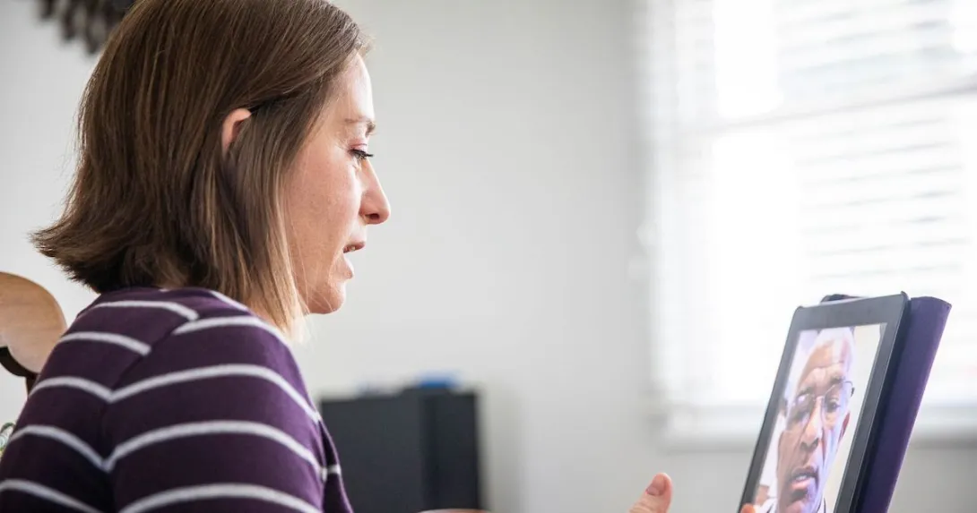 A person talking a provider using her tablet
