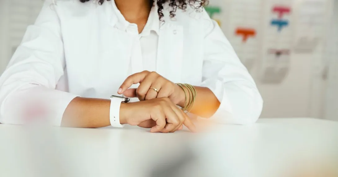 A close-up of a person sitting while wearing a smartwatch