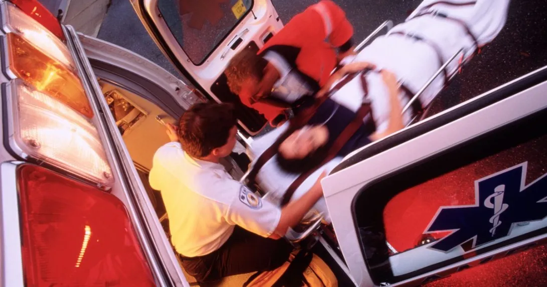 EMTs bringing a patient into an ambulance on a stretcher